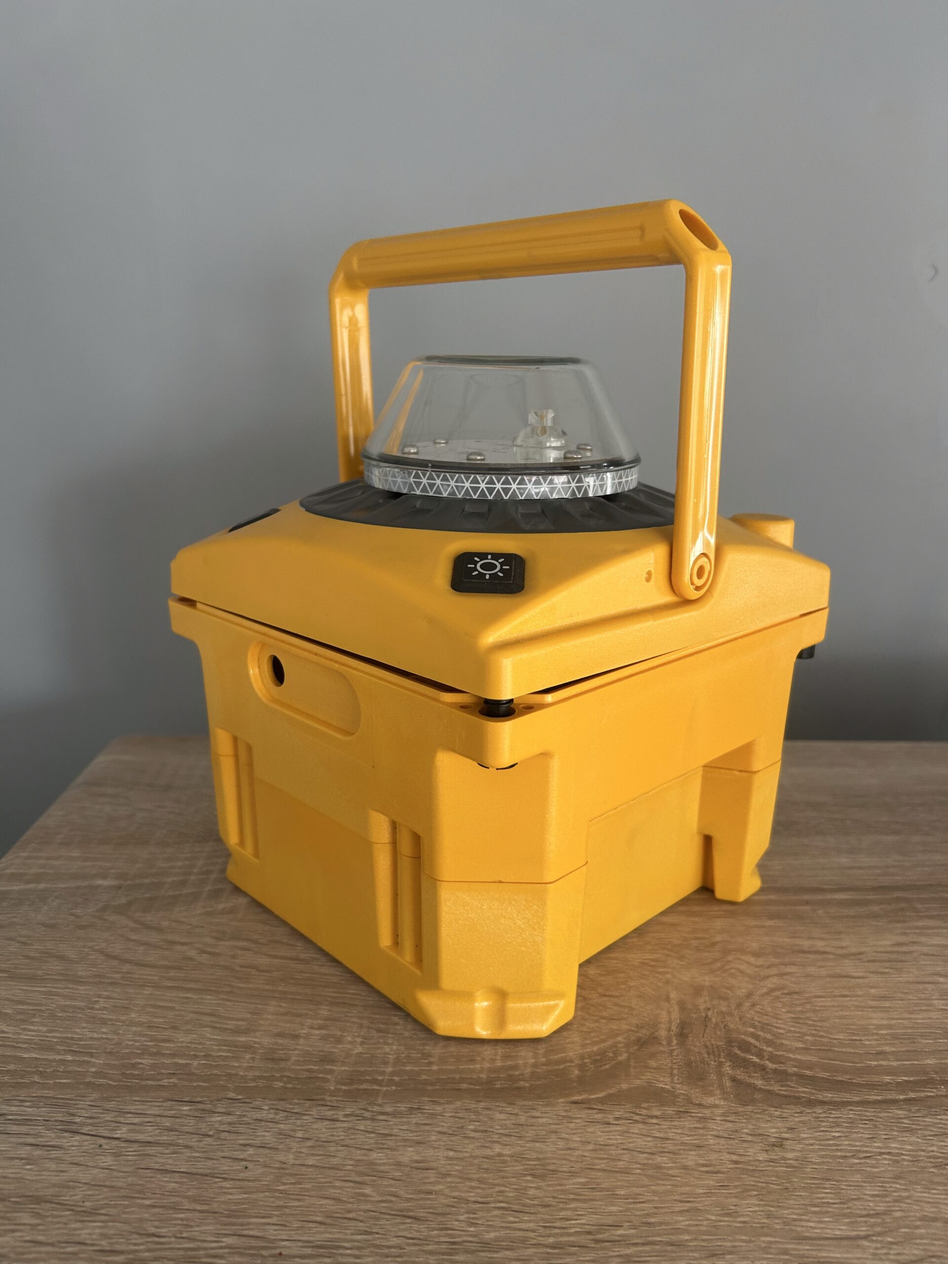 A yellow enclosure with a handle and transparent lid