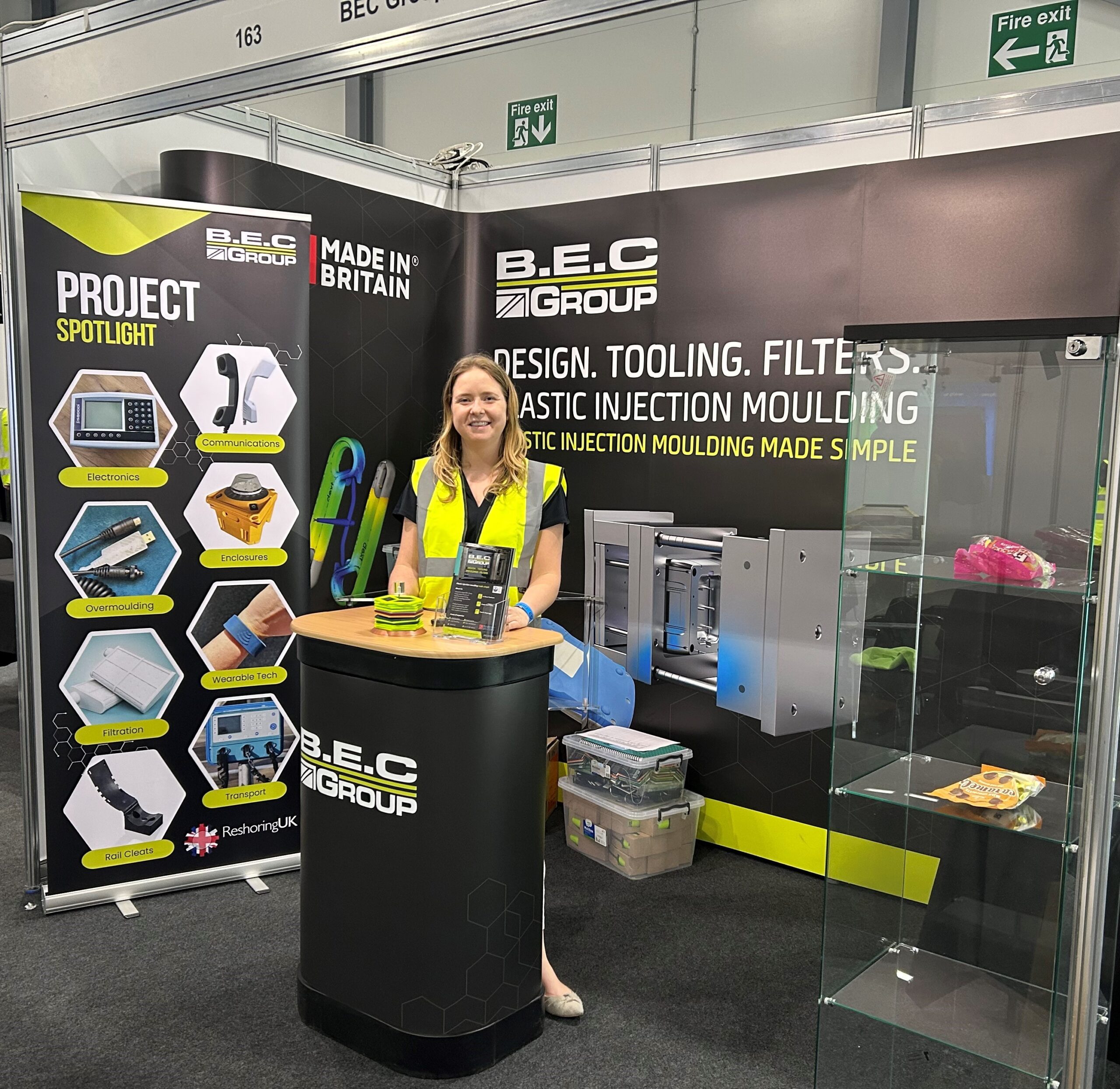 Woman stands behind podium on exhibition stand